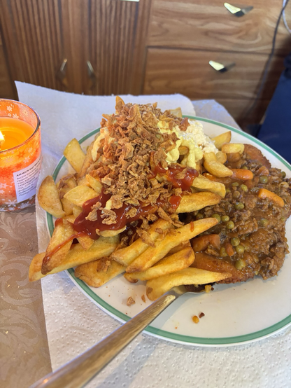 Schnitzel aus Hähnchenfleisch mit Pommes mit Ketchup Mayo Dänische Remoulade Röstzwiebeln auf dem Schnitzel ist Hackfleisch Soße