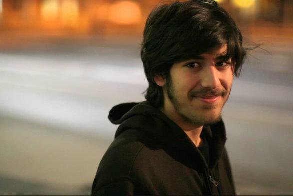 Foto de Aaron Swartz en la calle mirando a cámara con media sonrisa.