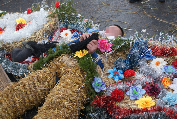 A person (face blurred by John) in an elaborate bear costume, related to Orthodox New Year celebrations