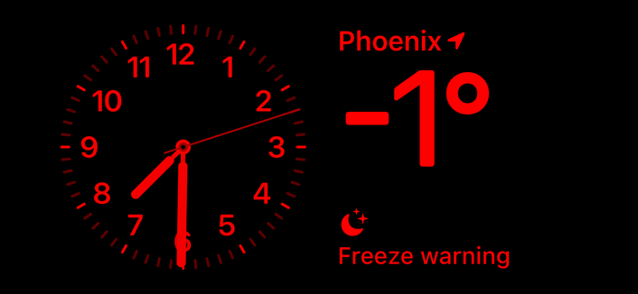 iPhone nightstand mode display. There is an analog clock showing 7:30, the local temperature of -1°, and a freeze warning alert. 