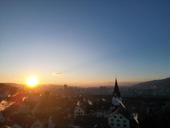 Sunrise behind the alps over Zurich. The Höngger church is also visible 
