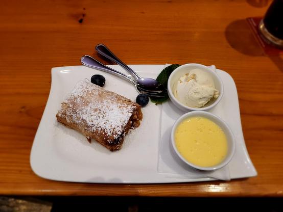 Freshly baked apple strudel with vanilla sauce and ice cream