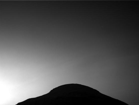 A black and white photography capturing the thinly veiled Martian sky above Wilkerson Butte.