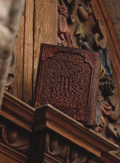 Photo features the back side of the leather covers for a notebook. These covers are all over decorated by hand carved floral and curvy motifs, so the back side is similar to the front with some small exceptions. As the floral motifs are drawn in such a shape that they frame beautifully the eye-like symbol on the front cover, I flipped it on the back side. This way the floral decorations frame the styled letter "M" on the back side. Color of the covers is mahogany. Photo background is colorful carved medieval door sill.