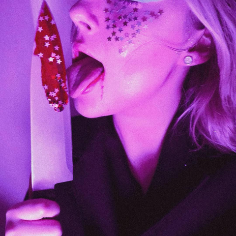 portrait d’une personne qui lèche un couteau avec du faux sang et des paillettes étoile 