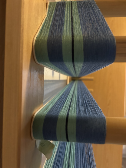 Cotton warp in 3 shades of blue on a warping board