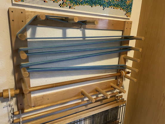 A warping board with a length of cotton warp of blue cotton thread