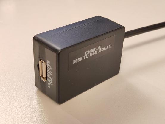 The case closed up, and the adapter assembled. It has white-on-black labels that say "CHARLIE, X68K TO USB MOUSE" and "USB MOUSE ONLY".