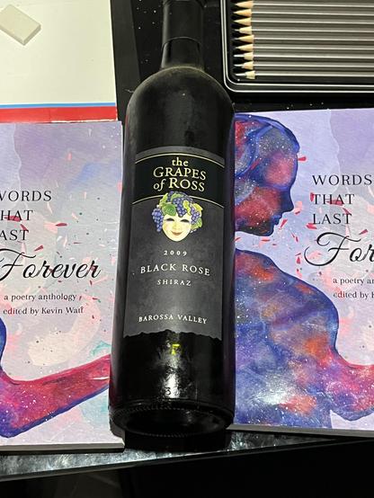 A bottle of Black Rose Shiraz from the Grapes of Ross vineyard, a hidden treasure unearthed from the depths of a Brisbane pantry. The rich, dark liquid within holds the promise of solace, a momentary respite from the heat of loss. It stands as a symbol of resilience, a testament to the enduring spirit that weathers the tempests of time. Though the years may have tested its resolve, the essence of the wine, like the essence of the poet, remains unbroken - a vintage of the heart, aged in the oak of experience.