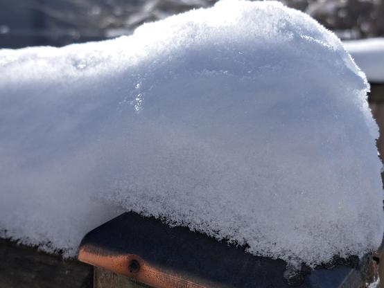Wooden railing covered in snow