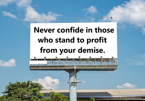 Photo of a white billboard with this simple message in black text: "Never confide in those who stand to profit from your demise." Blue sky with puffy white clouds fill the background, while treetops are visible at the bottom.
