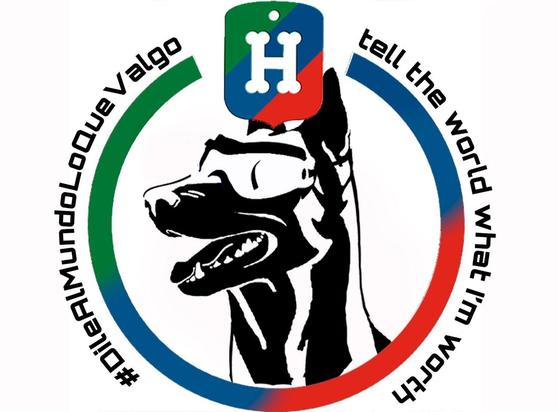 Logo #DileAlMundoLoQueValgo que desde la izquierda hace círculo abierto arriba con 'tell the world what I'm worth' a la derecha en una franja con los colores de Héroes de 4 patas cuyo escudo lo corona. En el centro en blanco y negro la silueta de la cara y cuello de un perro tipo pastor alemán con gafas protectoras.