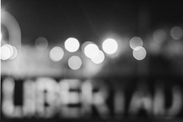 Fotografía nocturna desenfocada en la que se puede leer un cartel que pone libertad (está tomada en el parque de los Mártires de la Libertad en Huesca).