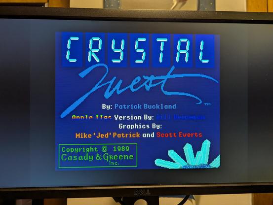 A photograph of a computer monitor displaying the loading screen for "Crystal Quest" for the Apple IIgs, from 1989.