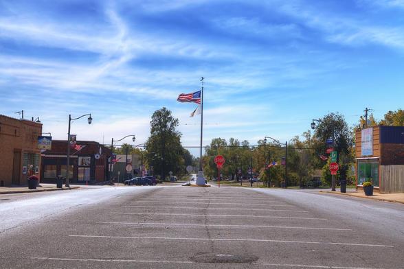 A quiet street captures the essence of a small town, with a flag waving gently above the scene