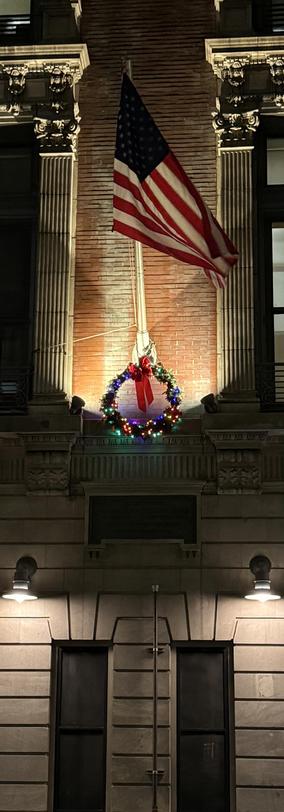 A photo of a flag and holiday wreath on the firehouse of ladder 25 on the upper west side of Manhattan. 
