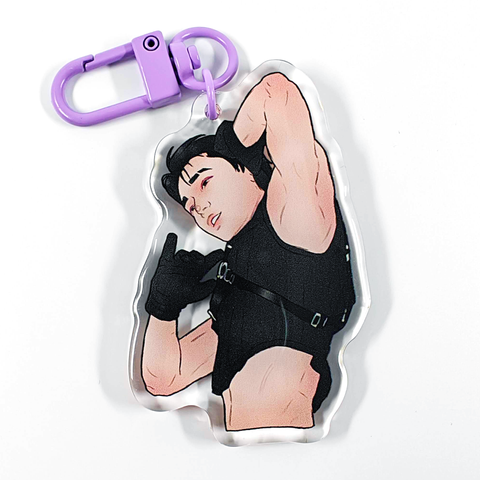 A picture of an acrylic keychain of San from ATEEZ, with short black hair, a black crop top and black gloves. He has his left arm up and you can see his armpit. The keychain has a light purple clasp.