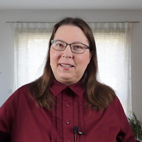 Close up of a woman in a red dress with button down collar and pintucks