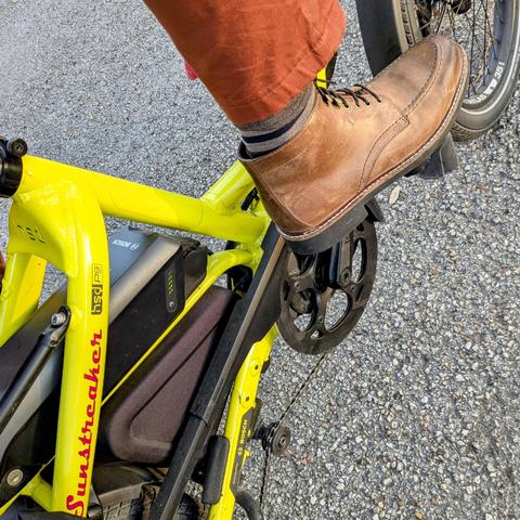 A photo of my right foot on the pedal of a 

yellow Tern HSD cargo bike with its name, Sunstreaker, in red on the seat stay

I'm wearing

brown short boots under a burnt orange pantleg