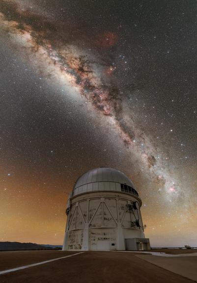 This Image of the Week showcases the stunning Milky Way gracefully arcing over the NSF Víctor M. Blanco 4-meter Telescope at the U.S. National Science Foundation Cerro Tololo Inter-American Observatory (CTIO), a Program of NSF NOIRLab in Chile. CTIO is located at an altitude of 2200 meters (7200 feet) in the remote mountains of Chile. This location, high in the sky and far from city light pollution, allows telescopes like the Blanco Telescope to study the sky in breathtaking clarity. This image encapsulates the beauty of the cosmos and the sophisticated efforts undertaken by astronomers to unravel its mysteries. One such effort in which this telescope has played a major role is the Dark Energy Survey (DES). The survey examined the origin of the accelerating Universe to uncover the nature of dark energy by measuring the 14-billion-year history of cosmic expansion. Over a six-year period, this telescope, armed with the Dark Energy Camera (DECam) fabricated by the U.S. Department of Energy, observed about two million distant galaxies and found several thousand supernovae. The results of this ambitious survey are being used to trace the history of cosmic expansion and study the nature of dark energy.

This photo was taken as part of the NOIRLab 2022 Photo Expedition to all the NOIRLab sites. Petr Horálek, the photographer, is a NOIRLab Audiovisual Ambassador.

Credit: CTIO/NOIRLab/NSF/AURA/P. Horálek (Institute of Physics in Opava)