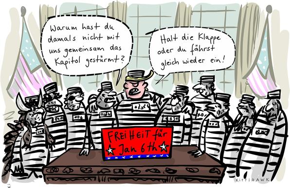 Karikatur: Trump steht im Sträflingsanzug vor einem Tisch. Um ihn herum stehen neun weitere Sträflinge. Auf dem Tisch steht ein Schild mit der Aufschrift: Freiheit für Jan 6th. Einer der Sträflinge fragt: Warum hast du damals nicht mit uns gemeinsam das Kapitol gestürmt? Trump antwortet: Halt die Klappe oder du fährst gleich wieder ein!