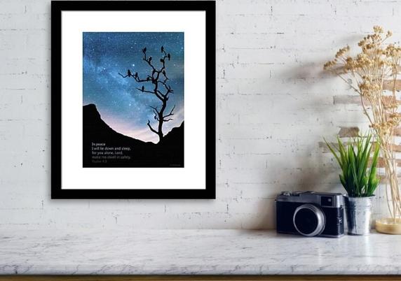 A night scene with stars and black mountains and silhouetted tree and birds with a Bible verse by artist Sharon Cummings.