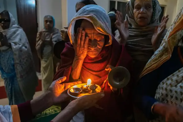 Vishakha Devi, 75, prays over a small oil lamp. 