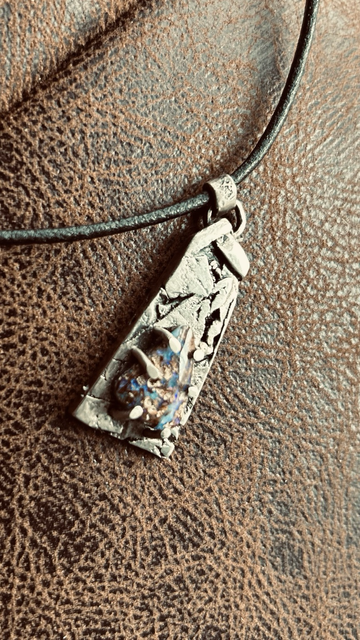 Pendentif en argent fusionné et martelé laissant des creux apparents, oxydé et serti d’une opale pipe boulder