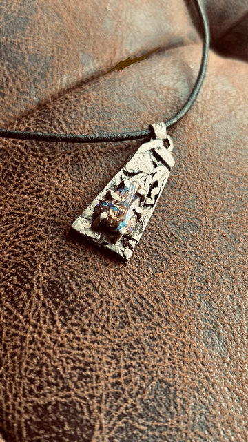 Photo vue de dessus pendentif argent serti d’une opale pipe Boulder tons violets, aspect d’une écorce d’arbre de l’argent 