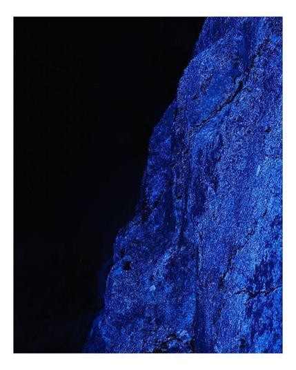 Granite rock bathed inn blue light on deep night black background