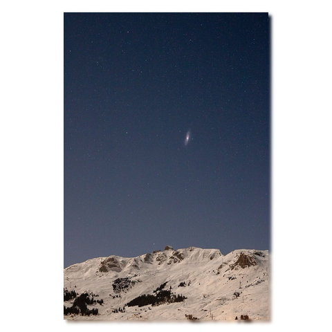 Galaxie d’Andromède visible au dessus de montagnes enneigées 