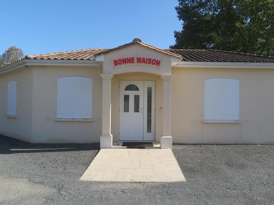 devanture de maison moche avec écrit "bonne maison" au dessus de la porte