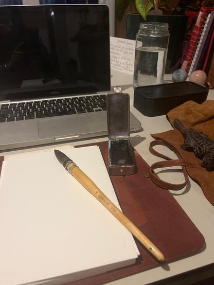Japanese brush, aquarel ink and A5 paper in front of a laptop