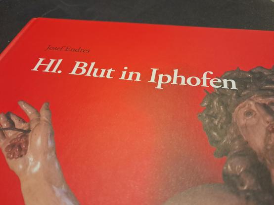 Teil eines Buchcovers - auf rotem Hintergrund steht der Titel "Hl. Blut in Iphofen" von Josef Endres