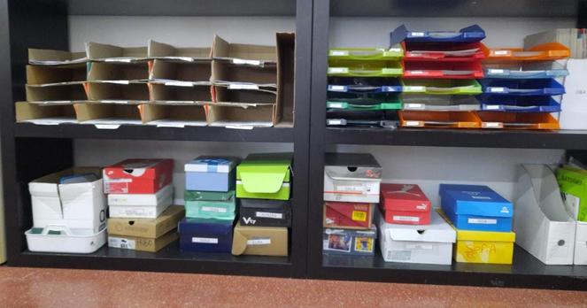Estanterías de aula con bandejas para colocar fichas se trabajo y cajas de zapatos para guardar material.