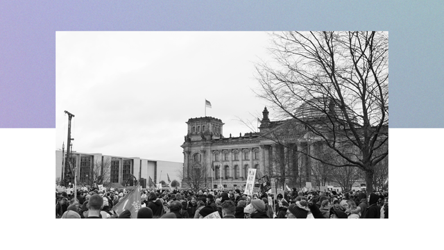 Das Bild zeigt eine demonstrierende Menschenmenge vor dem Bundestagsgebäude.
