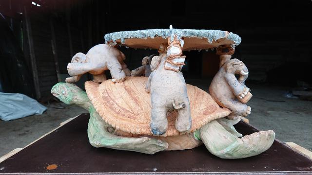 There's ceramic turtle named A'Tuin who has four elephants on its back and elephants hold the Discworld