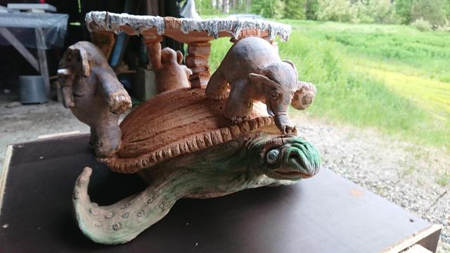 Discworld and A'Tuin the giant turtle and elephants that hold Discworld. One of the elephants is trying to guide turtle
