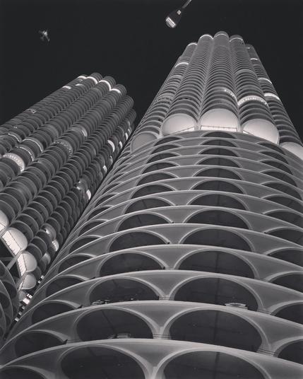 High contrast black and white photo of the Marina City towers, looking upwards at a steep angle. 