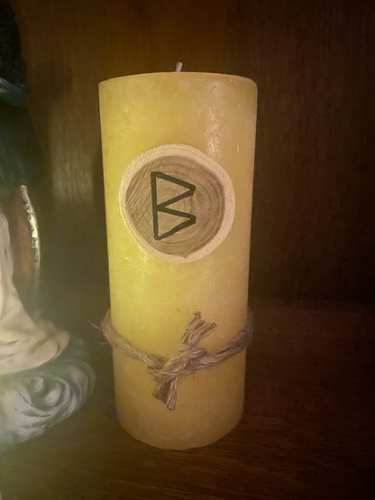 Yellow pillar candle dressed for Imbolc