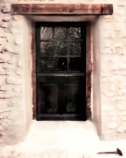 Une porte fermière en bois foncé avec des vitres, dans un mur de pierre. Au sol, en bas à droite, il y a un marteau.