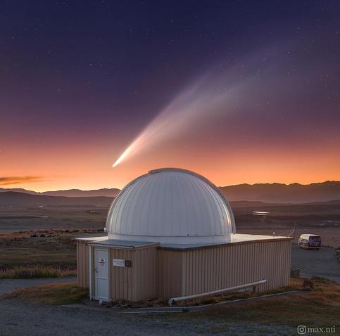 a bright comet seen above a mountaintop telescope observatory at sunset. Photo was taken in New Zealand's South Island near Tekapo.