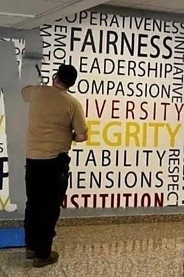 The wall of positive words being painted over