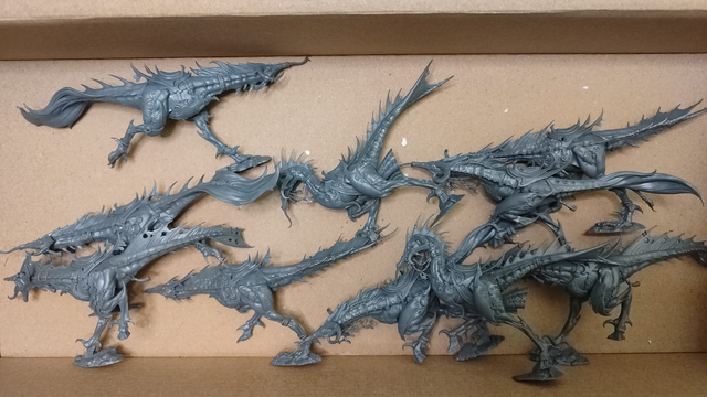 photo showcasing ten plastic miniatures,seekers from warhammer age of sigmar, which are a hybrid between day geckos, horses and monitor lizards, wearing jewelry,light plating and several decorations.