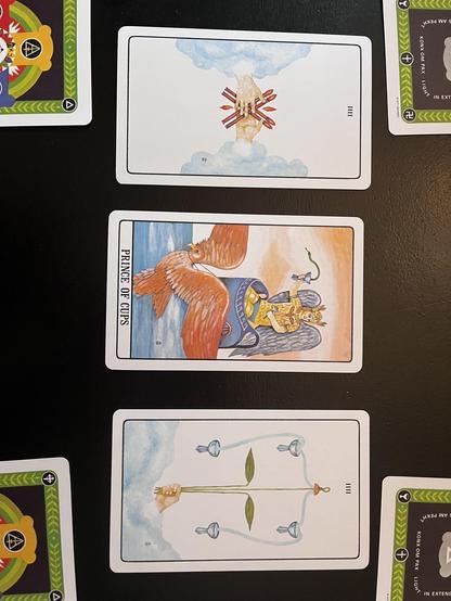 Photo of the central three cards in the reading my husband J did for our friend M. These cards indicate the heart of the matter. Deck used is the Golden Dawn, and from left to right the cards are: The 4 of Wands, The Prince of Cups, and The 4 of Cups. 
