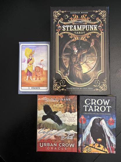 Photo of the boxes that contain the decks we used for our Imbolc readings: The Golden Dawn, Barbara Moore’s Steampunk Tarot, MJ Cullinane’s Crow Tarot, and Cullinane’s Urban Crow Oracle—box signed by the artist!
