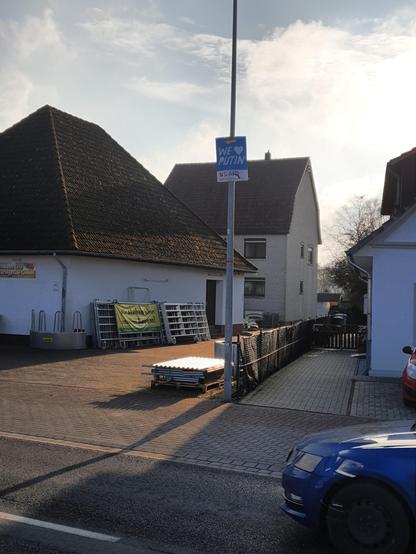Wahlplakat an einer Straßenlaterne im Gegenlicht der Februarsonne,  Grundfarbe Blau...