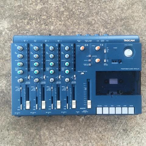 A Tascam 414mkII cassette multitrack recorder as seen from above, resting on a stone surface.