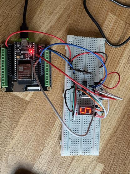 Ein ESP32 mit Development Board und Breadboard, auf dem eine prototypische Schaltung eines digitalen Würfels aufgebaut ist.