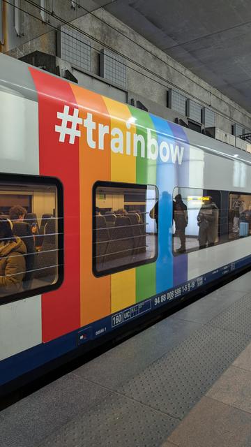 A NMBS/SNCB class 08 EMU, the usual livery is combined with a vertical stripe in rainbow colours, labelled with "#trainbow"